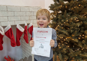 Chłopiec trzyma dyplom.