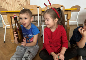 Dzieci oglądają butelkę z listem.