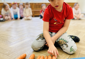 Dziecko liczy marchewki.