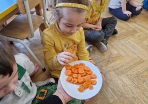 Dziecko częstuje się marchewką.