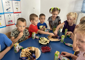 Dzieci z grupy czwartej jedzą słodycze.