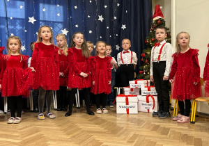 Dzieci stoją i śpiewają pastorałkę ,,Skrzypi wóz".