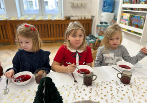 Dziewczynki z grupy czwartej jedzą obiad wigilijny - barszczyk czerwony.