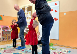 Dziewczynka tańczy z Dziadkiem na gazecie.