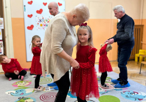 Dziewczynka tańczy z Babcią na rozłożonej gazecie.