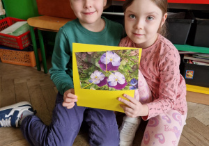 Dziewczynka i chłopiec trzymają ułożone puzzle.