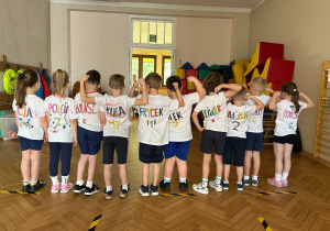 Zdjęcie grupowe - grupa IV. Dzieci stoją w jednym rzędzie w ozdobionych przez siebie koszulce.