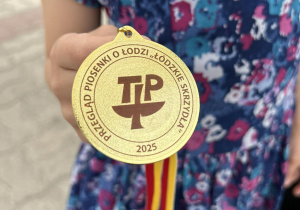 Dziewczynka pokazuje złoty medal.