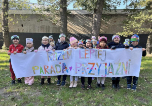 Dzieci trzymają transparent „Razem lepiej. Parada Przyjaźni".
