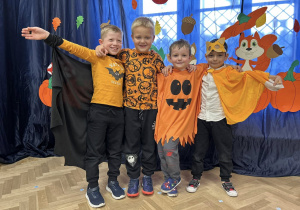 Zdjęcie grupowe - chłopcy z grupy IV. Chłopcy w strojach jesiennych stoją na tle dekoracji.