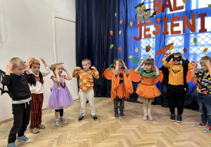 Dzieci z grupy IV ustawieni w półkolu i tańczą.