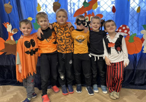 Zdjęcie grupowe - chłopcy z grupy IV. Chłopcy w strojach jesiennych stoją na tle dekoracji.