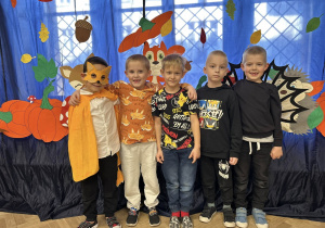 Zdjęcie grupowe - chłopcy z grupy IV. Chłopcy w strojach jesiennych stoją na tle dekoracji.