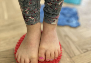 Stopy dziecka na ścieżce sensorycznej.