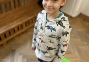 Dziecko chodzi gołymi stopami po ścieżce sensorycznej.