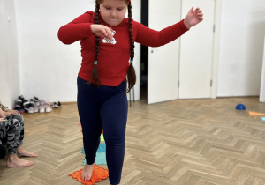 Dziecko chodzi gołymi stopami po ścieżce sensorycznej.