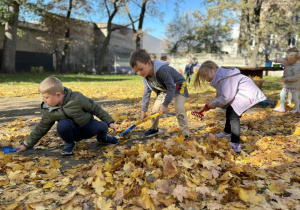 Dzieci grabią liście.