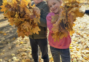 Dzieci trzymają w rączkach liście.