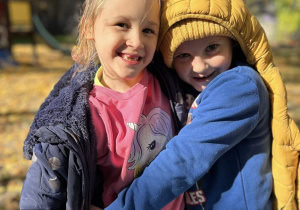 Chłopiec i dziewczynka przytulają się do siebie.