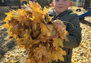 Dziecko trzyma w rączkach liście.