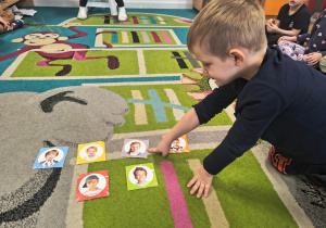 Chłopiec pokazuje małą plansze z obrazkiem dziewczynki.