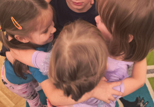 Dzieci przytulają się do siebie.
