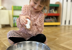 Dziecko wrzuca do miski piankę do golenia.