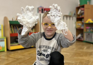 Dziecko włożyło ręce do miski z pianką do golenia.