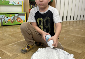 Dziecko wrzuca do miski piankę do golenia.