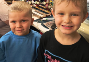 Na zdjęciu widoczni są chłopcy, uśmiechają się.