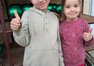 Chłopiec i dziewczynka uśmiechają się do zdjęcia.