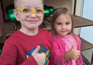 Chłopiec i dziewczynka uśmiechają się do zdjęcia.