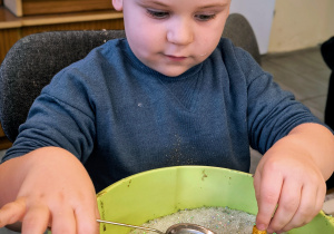 Dziecko ozdabia bombkę.