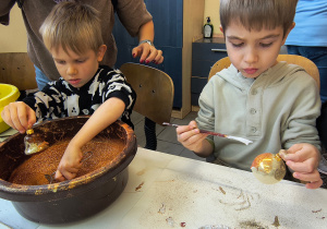 Dziecko ozdabia bombkę.