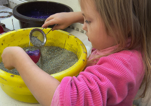 Dziecko ozdabia bombkę.