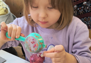 Dziecko ozdabia bombkę.