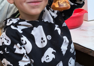 Dziecko pokazuję ozdobioną przez siebie bombkę.