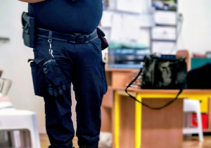 Pan ze straży miejskiej omawia dane zagadnienia o bezpieczeństwie.