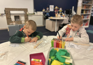 Dzieci ozdabiają swoje kukiełki.