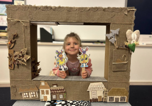 Dziecko pokazuje swoje kukiełki.