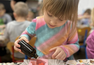 Dziewczynka ozdabia swoje mydełko.