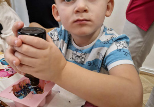 Chłopiec dodaje do swojego mydełka zapach.