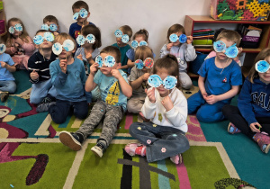 Zdjęcie grupowe- dzieci trzymają wykonane przez siebie okulary.