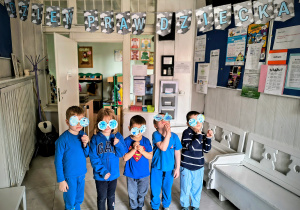 Dzieci stoją w szatni pod napisem Dzień Praw Dziecka