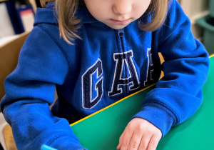 Dziecko ozdabia na niebiesko swoje okulary