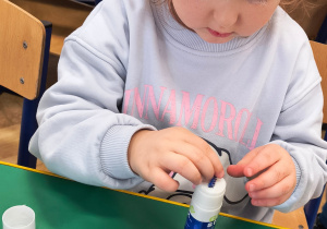 Dziecko ozdabia na niebiesko swoje okulary