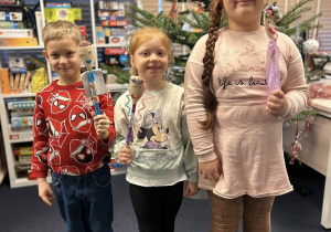 Dzieci pokazują swoje kukiełki wykonane z łyżki i innych materiałów.