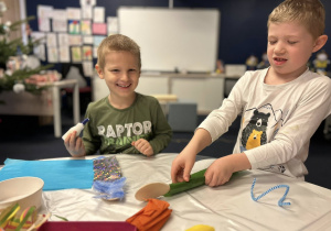 Dzieci przygotowują swoje kukiełki z bibuły, kolorowych kartek, pomponów, drucików i plasteliny.