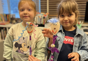 Dzieci pokazują swoje kukiełki wykonane z łyżki i innych materiałów.