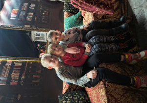 Dzieci przytulają się do siebie, siedzą na kanapie.